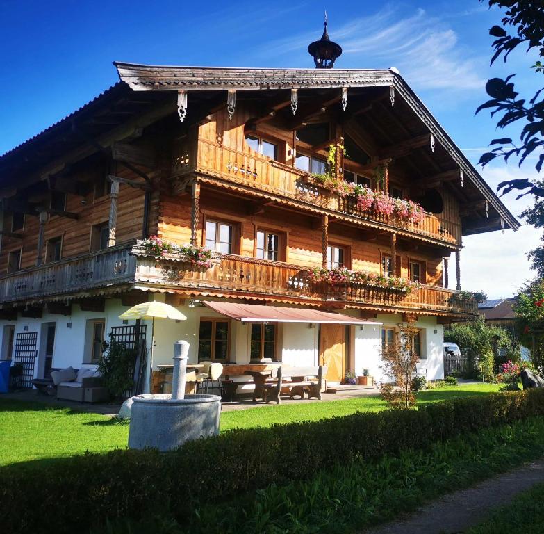 a large wooden building with balconies and tables at biohof Stiedler in Sankt Johann in Tirol