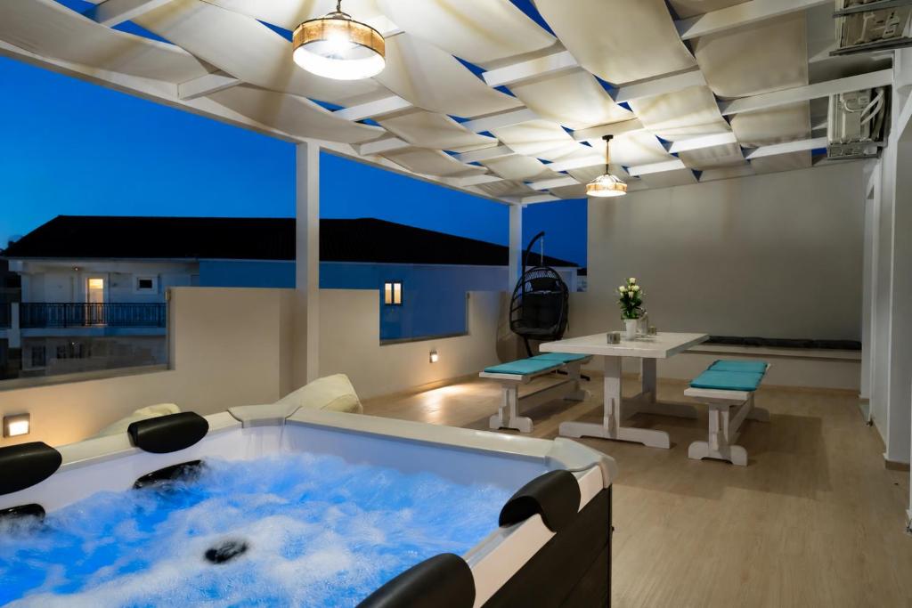 a hot tub in a living room with a table and chairs at Villy Suites - Zante Luxury Suites near the Sea in Argassi