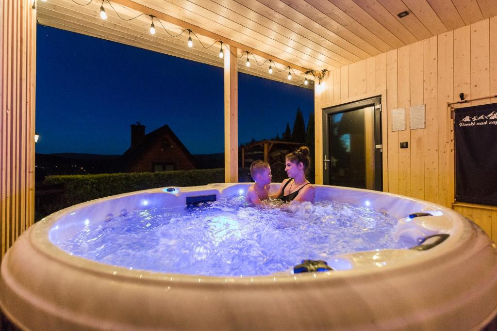 two people in a jacuzzi tub in a house at Domki nad Zaporą w centrum Soliny przy Zaporze - wybrane domki z jacuzzi in Solina