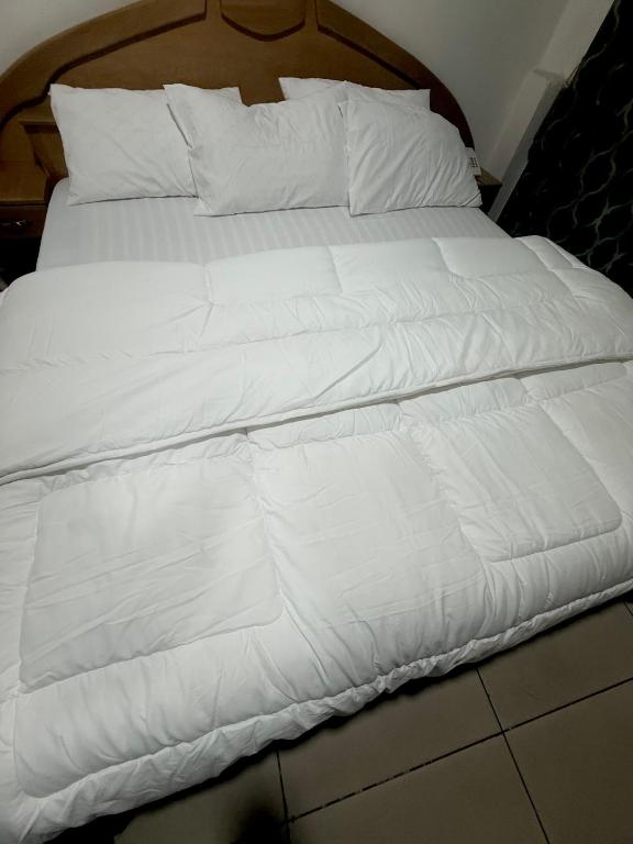 a white bed with white sheets and pillows at O Ansah Plaza Lodge in Kumasi