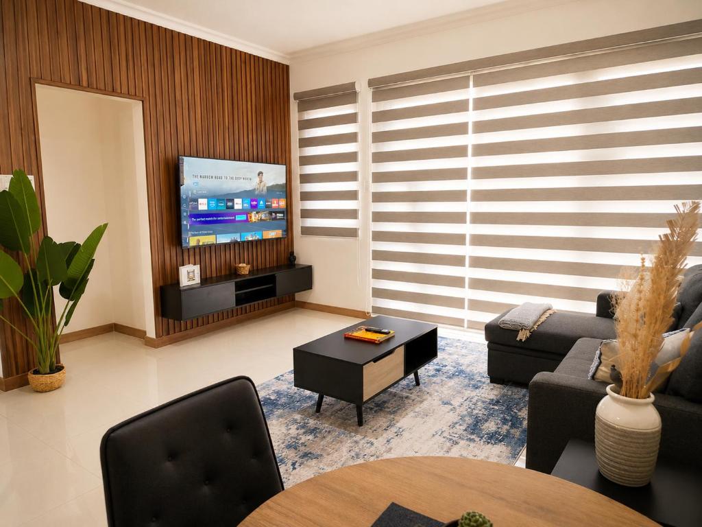 a living room with a couch and a tv at The Nook in Kingston