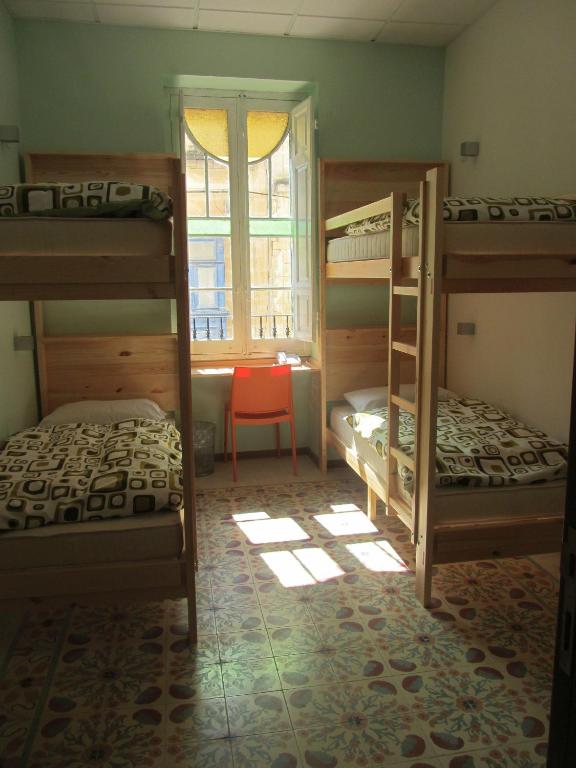 a bedroom with two bunk beds and a window at Corner Hostel in Sliema