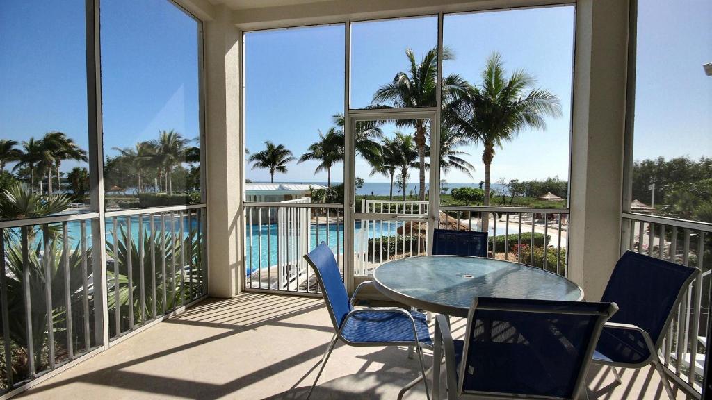 a balcony with a table and chairs and a pool at 411 Mariners Club in Key Largo