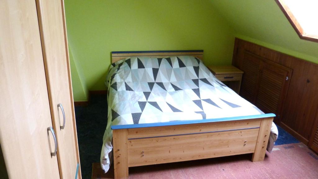 a small bedroom with a bed in a green room at Peace Room in Veigné