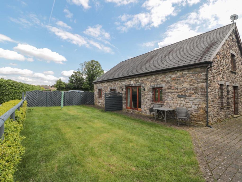 an old stone building with a grass yard at Longside in Abergavenny
