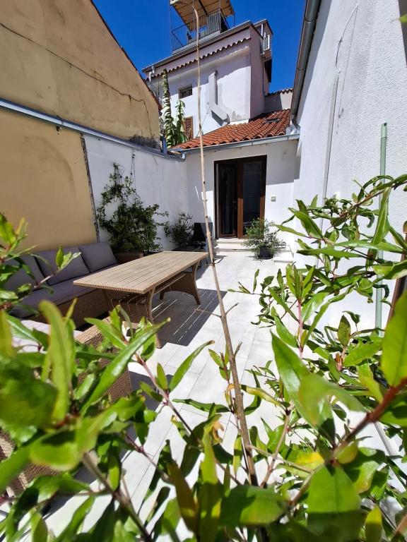 a patio with a wooden bench in front of a building at Tre sorelle in Piran