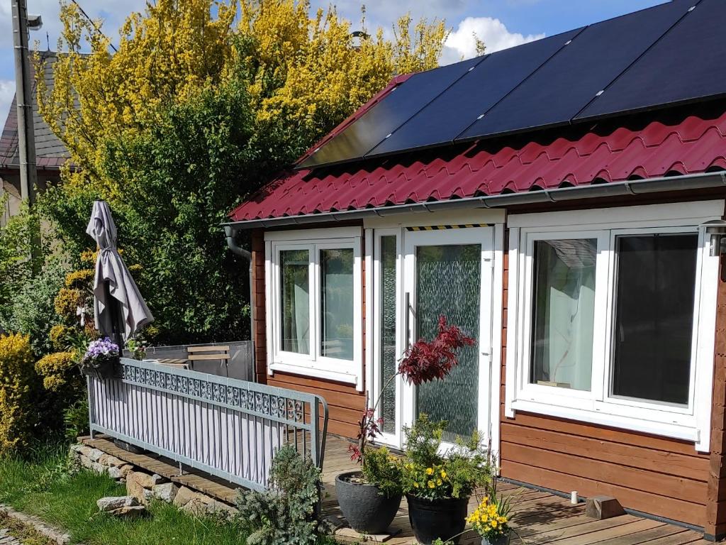 a house with solar panels on its roof at Ferienhaus Tinylausitz mit Kamin und Sauna in Steina