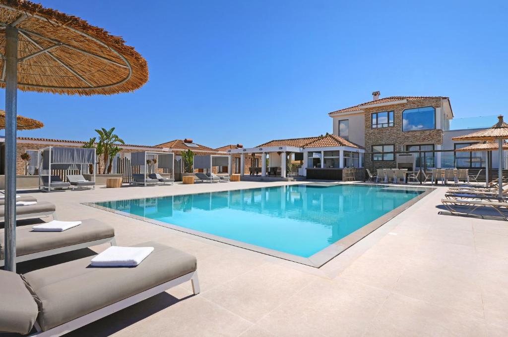 a swimming pool with lounge chairs and a house at Cape Serenity Mansion in Ayia Napa