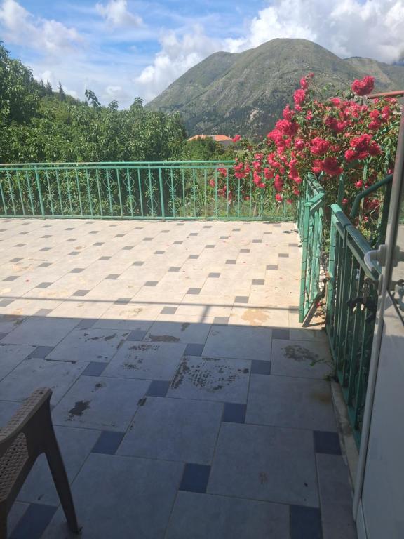 a balcony with red flowers on a fence at Apartament Dukat Albania in Dukat