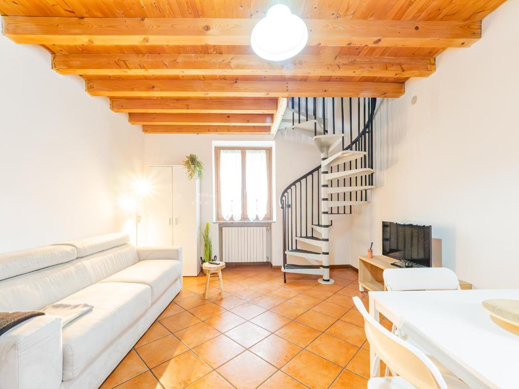 a living room with a white couch and a staircase at White Nest - Lake Como & Ski Area in Ballabio