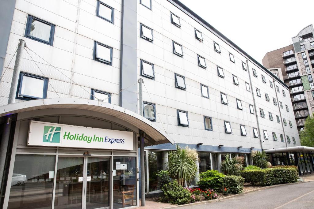 a large white building with a sign in front of it at Holiday Inn Express Royal Docks by IHG in London