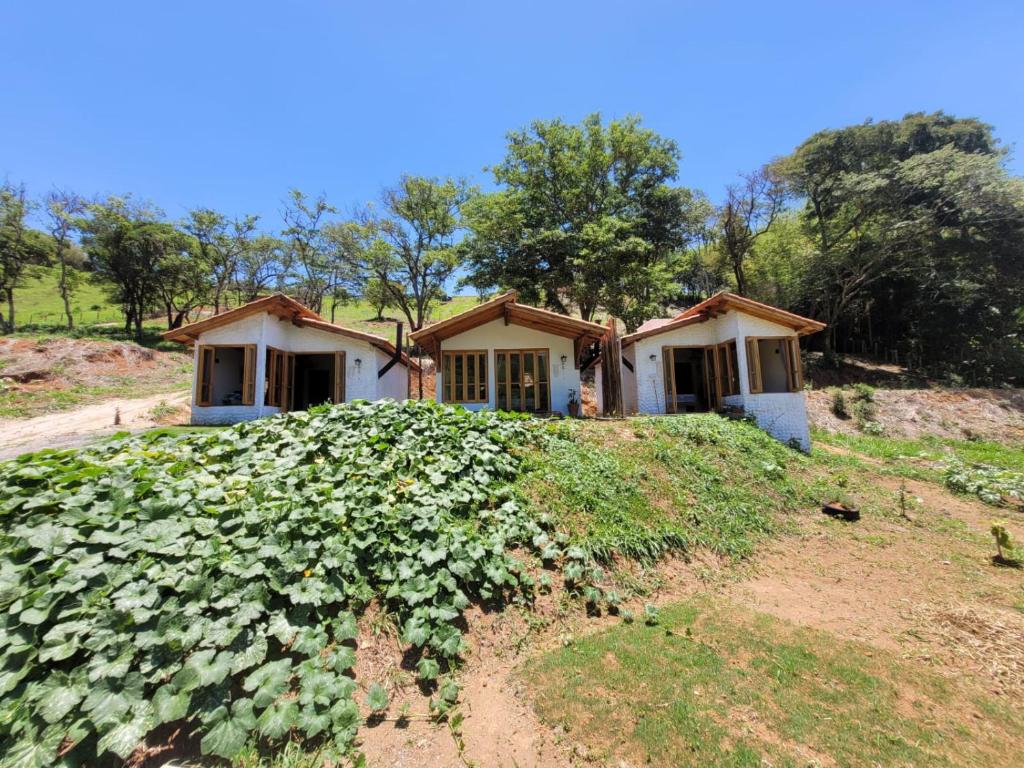 ein Haus auf einem Hügel mit einem Blumenstrauß in der Unterkunft Chalé Tekoá - Aroeira, Baraúna e Juazeiro in Córrego do Bom Jesus