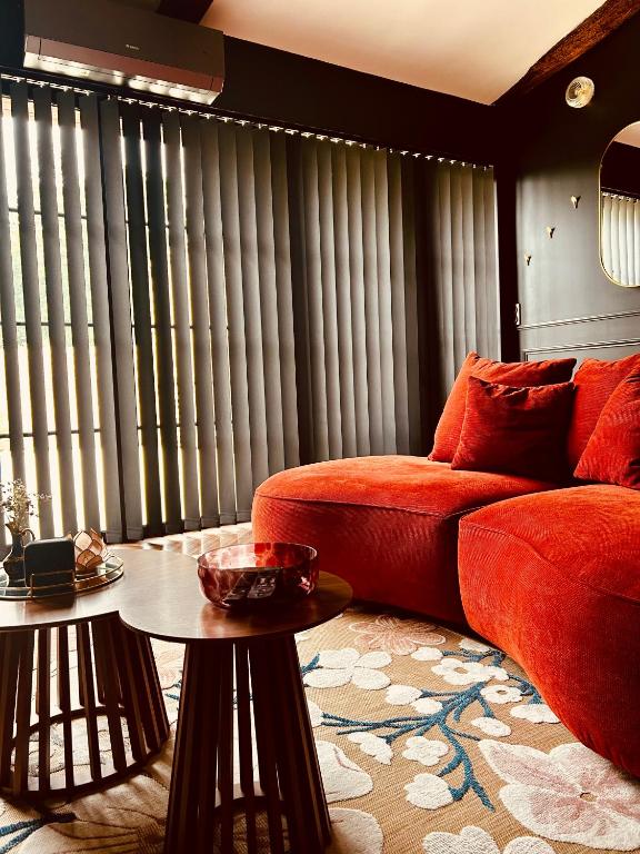 a living room with a red couch and a table at Clos des Voluptés in Fargues-Saint-Hilaire