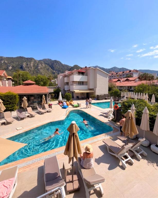 a pool with chairs and people swimming in it at Ida Hotel in Marmaris