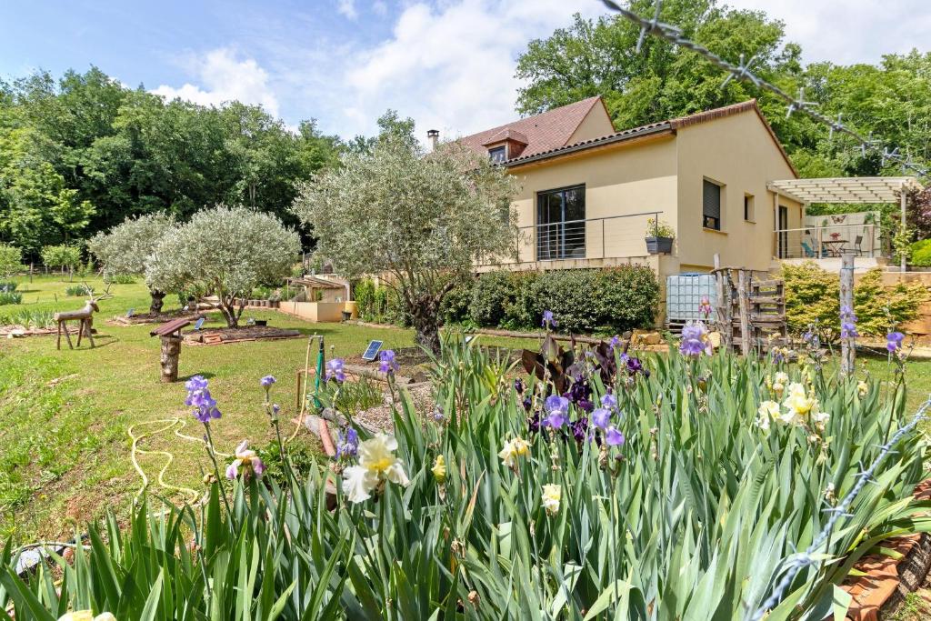 a garden in front of a house with flowers at Au Cerf Blanc Suite Parentale in Les Eyzies-de-Tayac