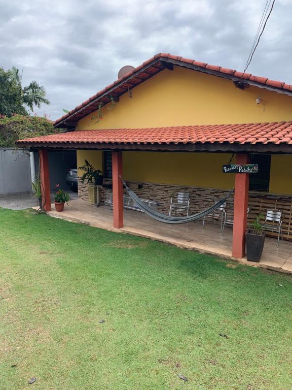 a yellow building with chairs in front of it at Recanto Pedrita in Pedreira