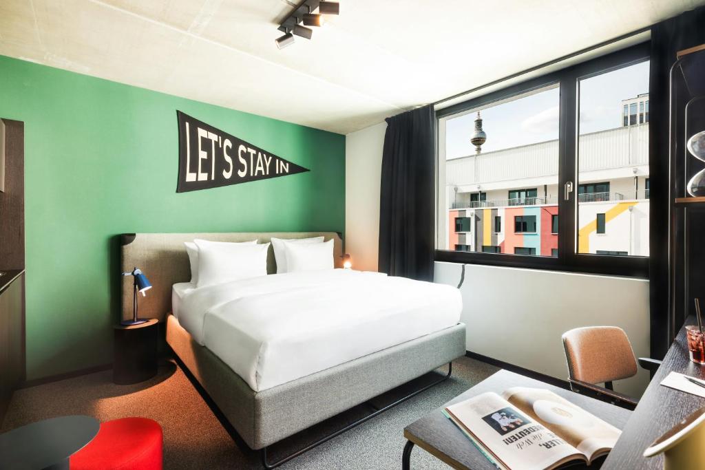 a bedroom with a bed and a green wall at The Social Hub Berlin Alexanderplatz in Berlin