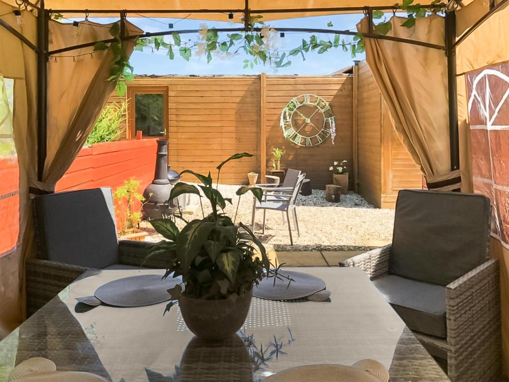 a patio with a table with a potted plant on it at Cow Boy Cabin - Uk47145 in Glasgow
