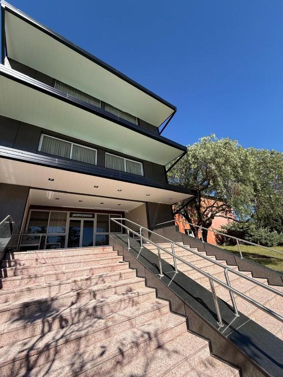 a building with stairs in front of a building at Peko's Multiparque Hotel in Villa Santa Cruz del Lago