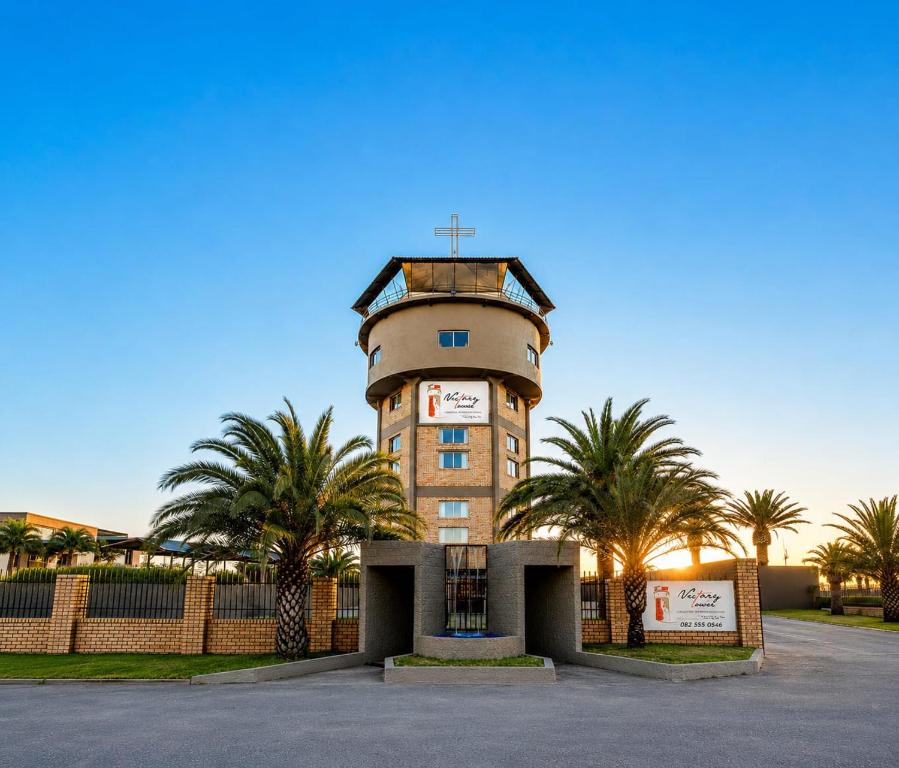 a tower with palm trees in front of a building at Victory Towers in Bloemhof