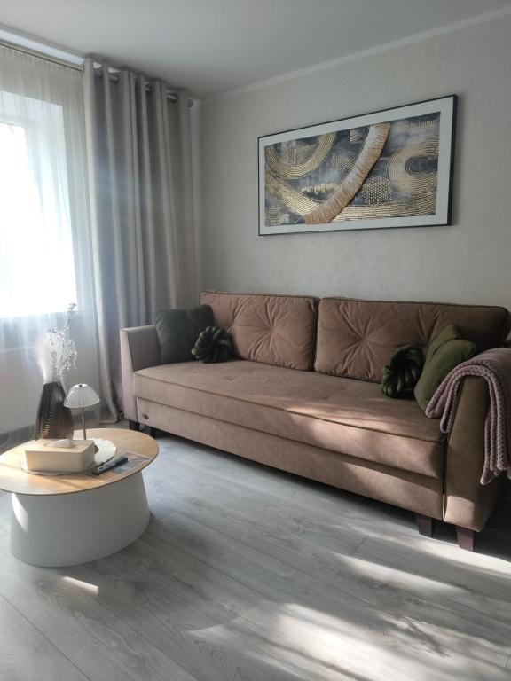 a living room with a brown couch and a table at JOJO Loft Comfort Dzelzavas & Cozy Stay & Breakfast Gift in Riga