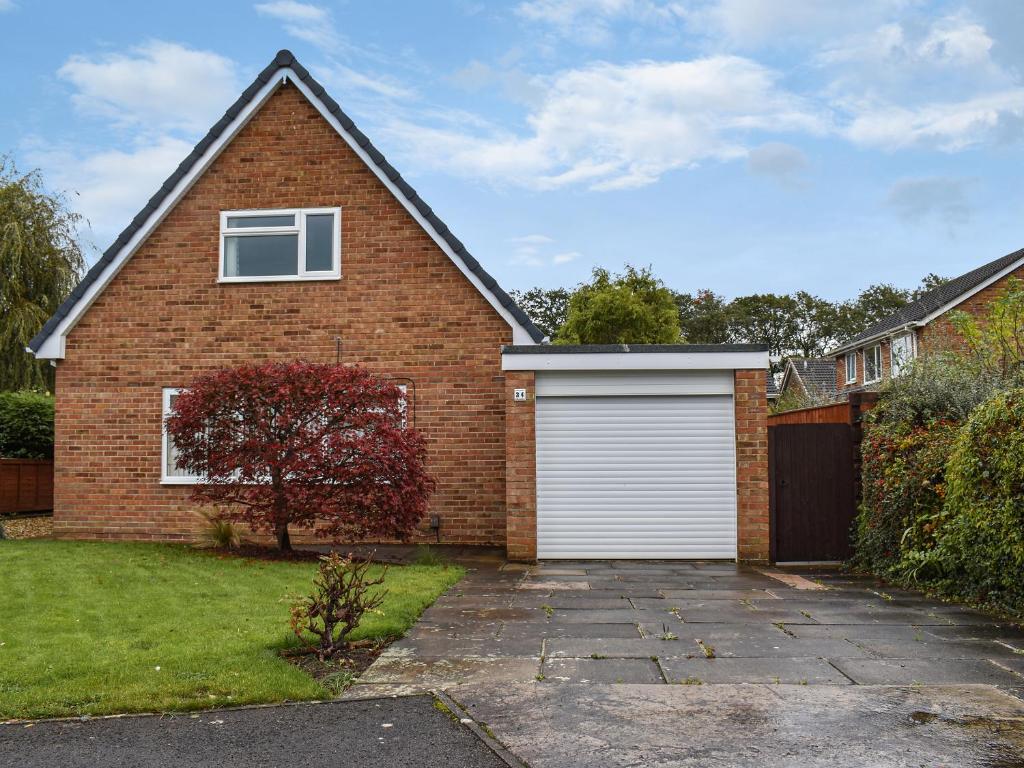 a red brick house with a white garage at Pine Hill Lodge in Guisborough