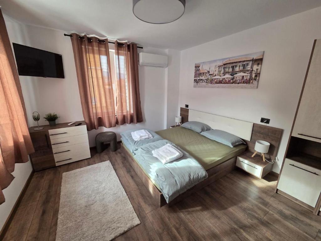 a bedroom with a bed and a television in it at The Cosy House in Kyustendil