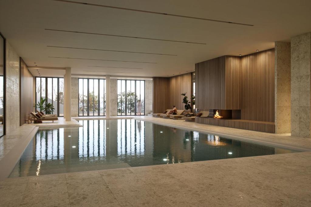 a swimming pool in a building with glass windows at THE SHORELINE Sellin in Ostseebad Sellin