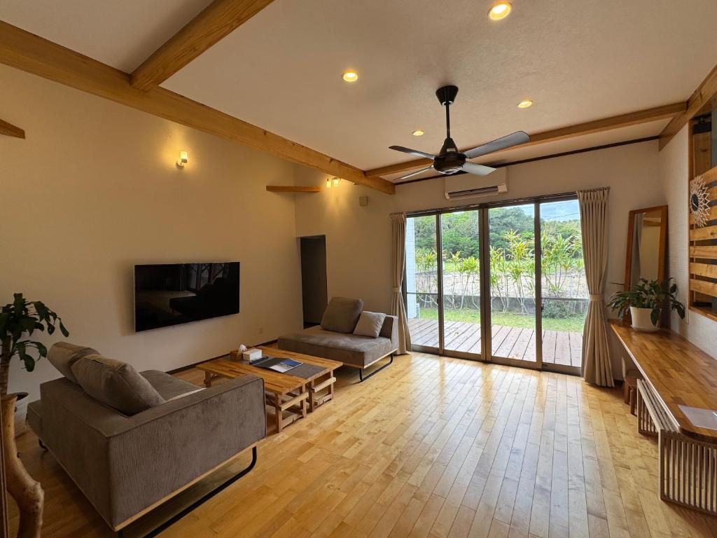 a living room with a couch and a table at SerenityBlueAmami in Tatsugo