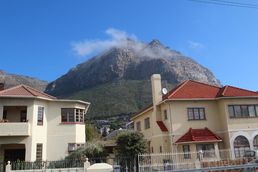 a mountain in the background with houses in front at Muizenberg Surfers Lodge in Muizenberg