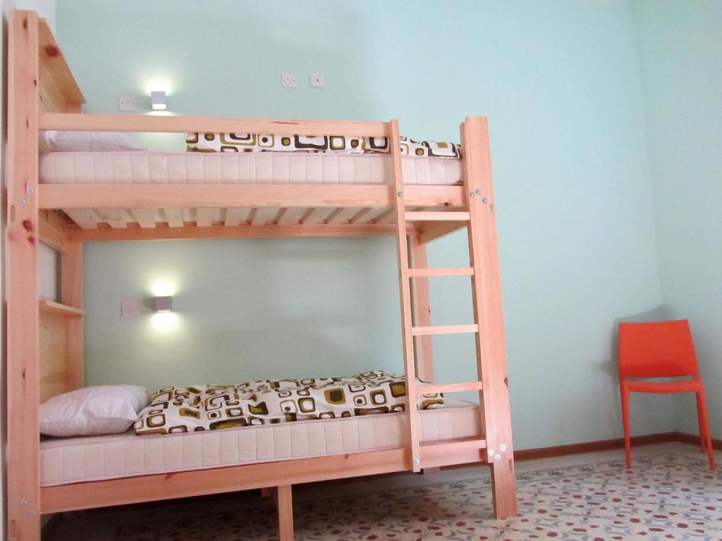 two bunk beds in a room with a ladder at Corner Hostel in Sliema