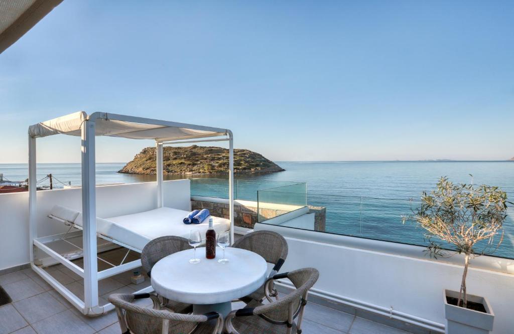 a balcony with a table and a view of the ocean at Seafront Villa Moments, by Estia in Mochlos