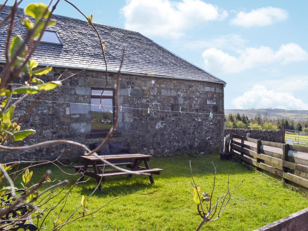 a picnic table in front of a stone building at Old Barn Cottage - Uk47144 in Glasgow
