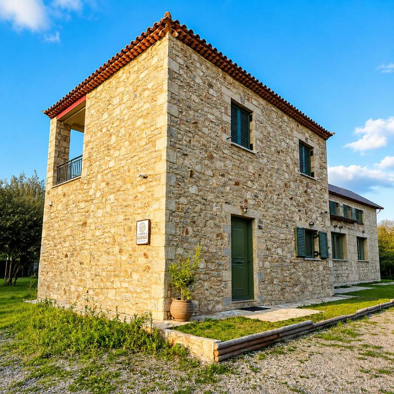 a large brick building with a green door at Olive Coast House 3 100m from the sea in Kyparissia