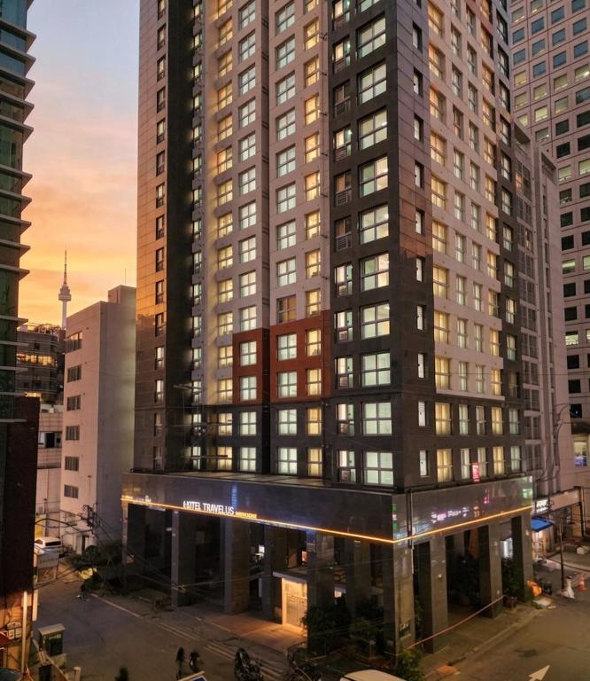 a large building in a city with people in front of it at TRAVELUS Myeongdong 트래블어스 명동 in Seoul