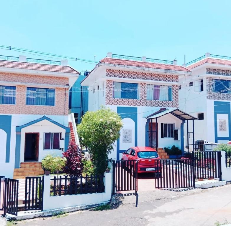 a red car parked in front of a house at Blue Pearl Cottage in Ooty
