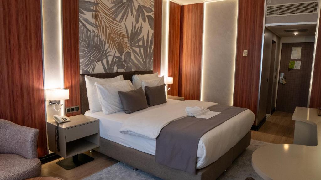a hotel room with a bed and a chair at Plaza Hotel Diyarbakir in Diyarbakır