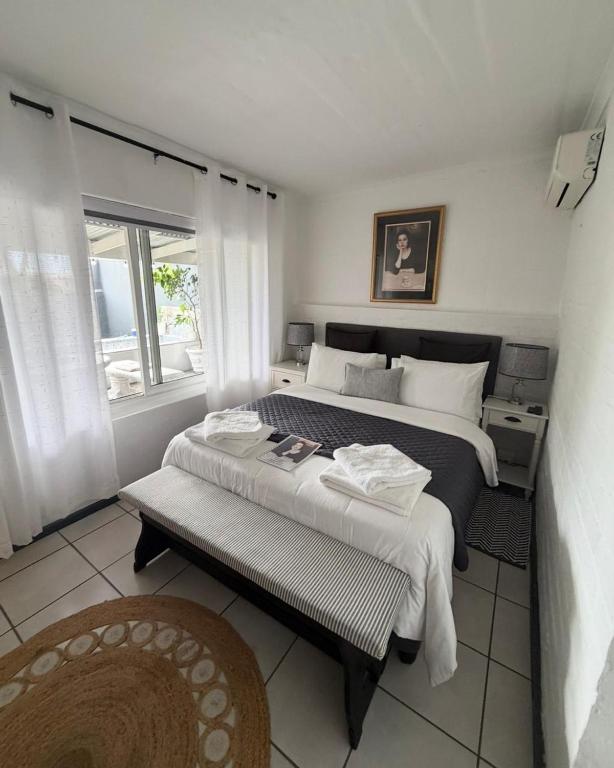 a bedroom with two beds and a window at Strand Stay Cottage in Strand