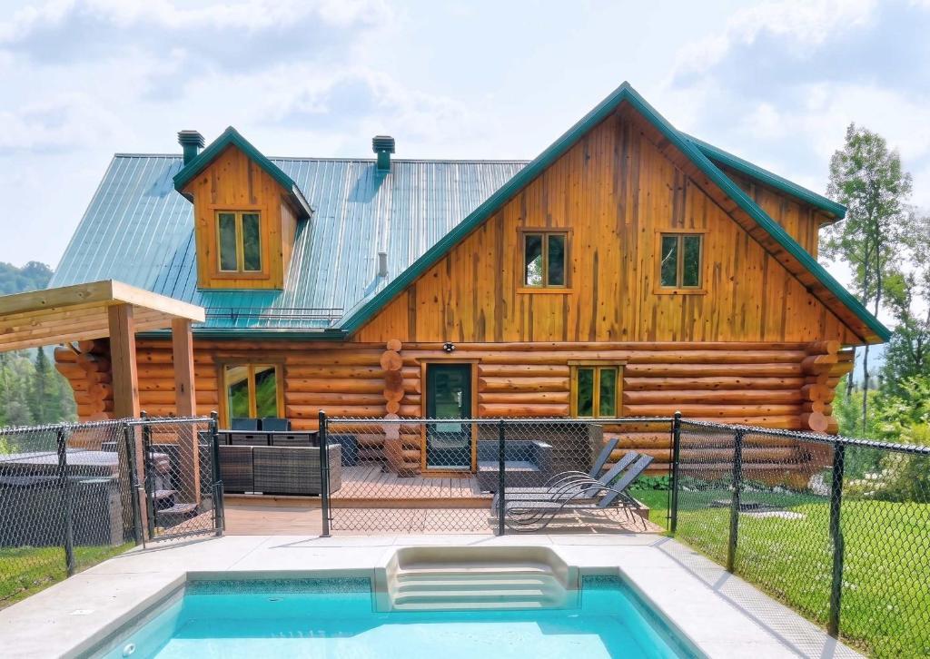a log cabin with a pool in front of it at Private Pool - Spa - Pool Table - Le St-Come in Saint Come