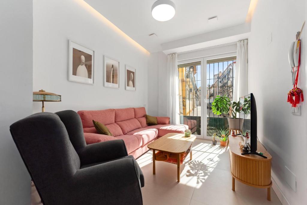a living room with a pink couch and a table at La casa del Pan in Málaga