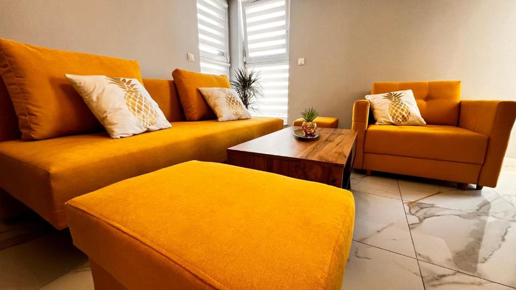 ein Wohnzimmer mit zwei orangefarbenen Sofas und einem Tisch in der Unterkunft Bydgoszcz GOLD 7 z sypialnią in Bydgoszcz