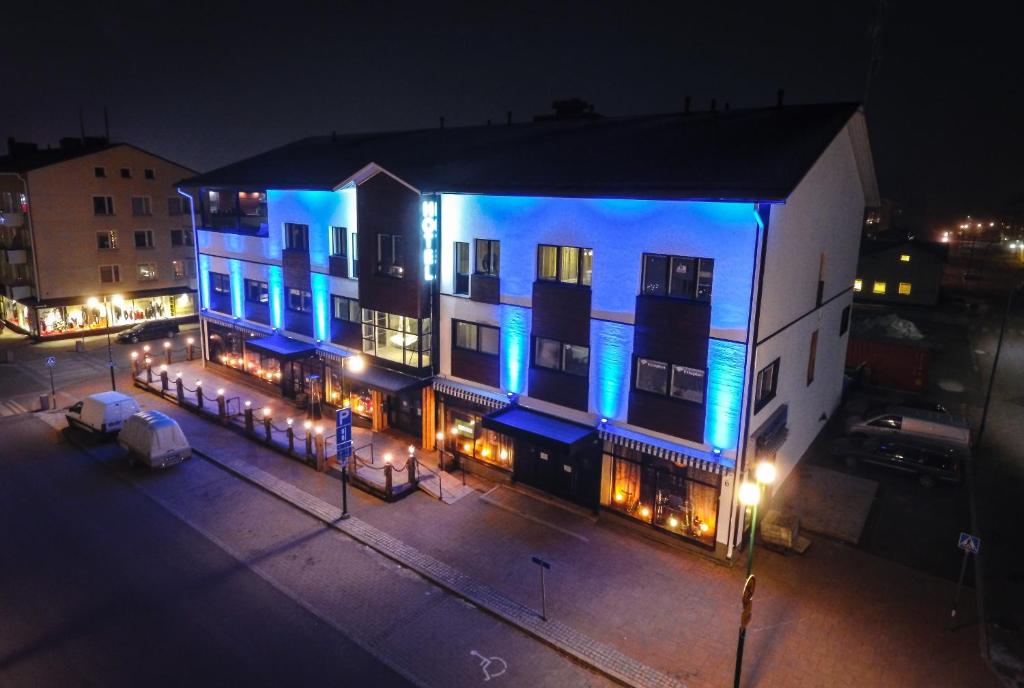 un edificio con luces azules por la noche en Boutique Hotel Mustaparta en Tornio