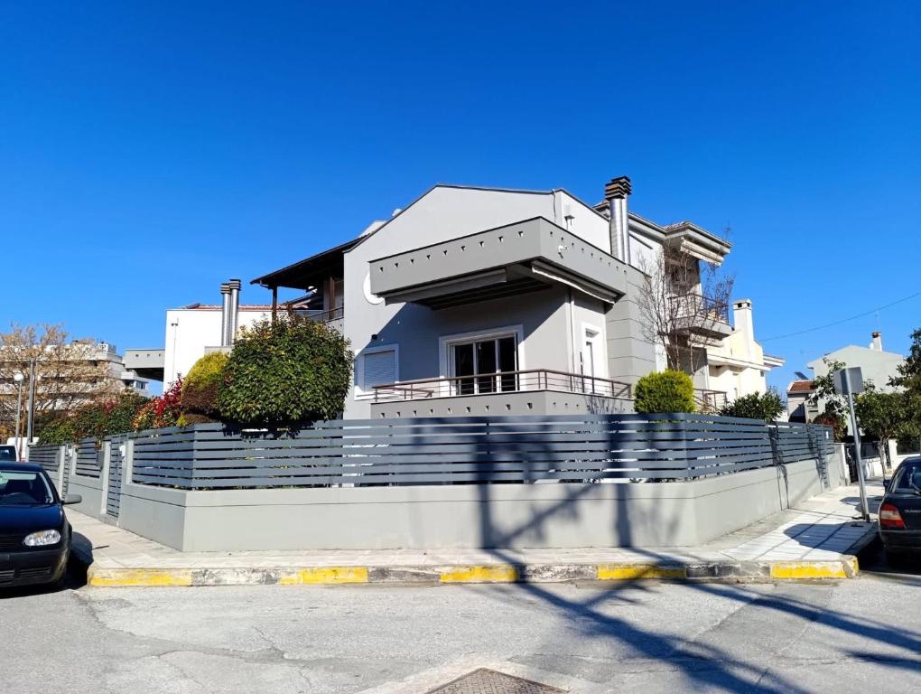 a white house sitting on top of a building at Raphael Guesthouse in Tríkala