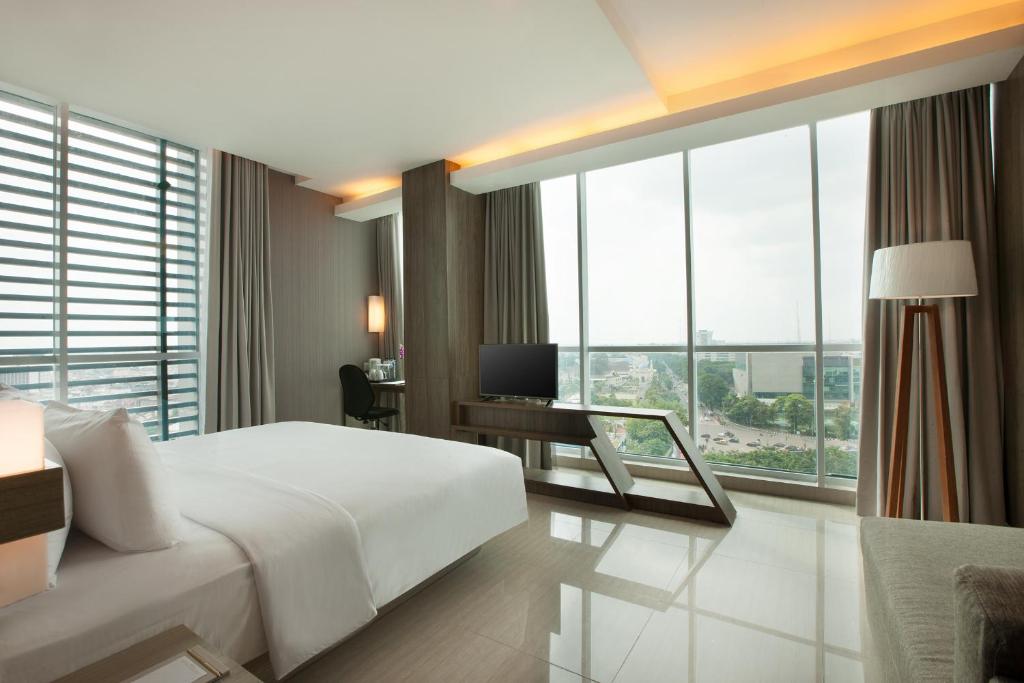 Postel nebo postele na pokoji v ubytování Hotel Santika Radial Palembang