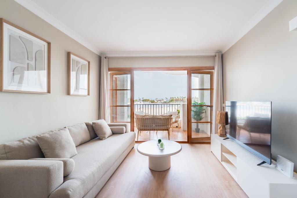 a living room with a couch and a tv at CARABELA 92 in Alcudia