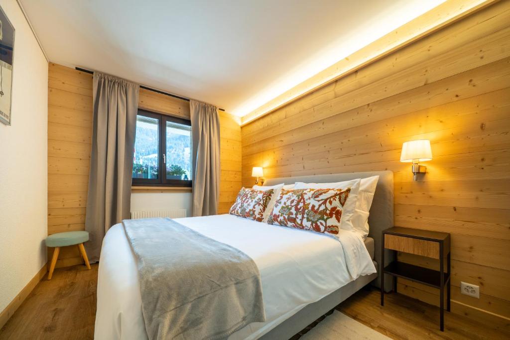 a bedroom with a bed with a wooden wall at Balmoral in Champéry
