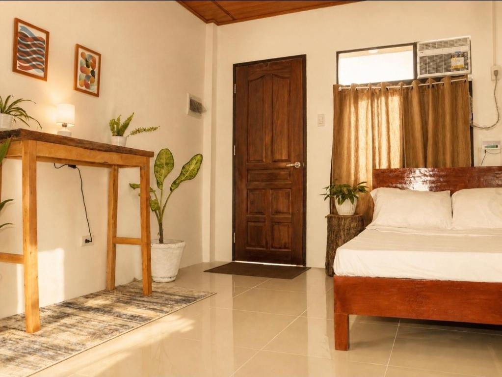 a bedroom with a bed and a wooden door at Pahuway - Comfort and style in Moalboal