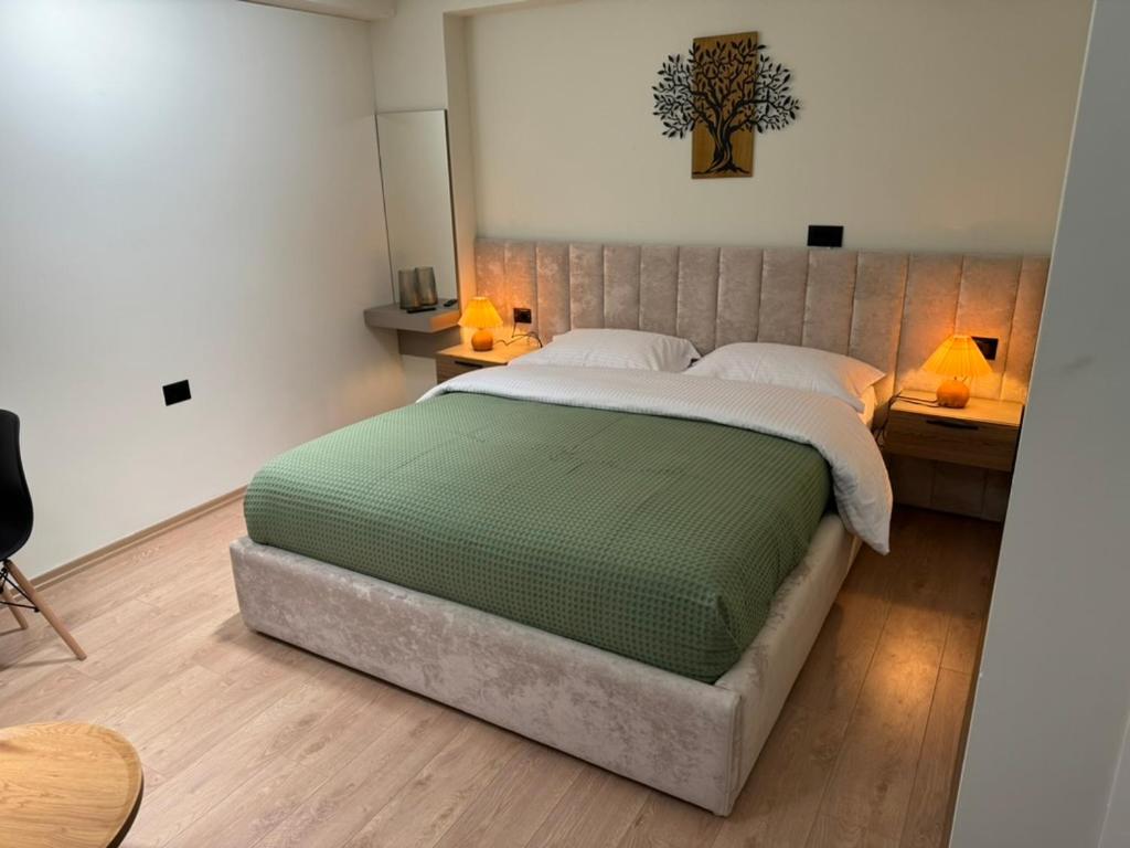 a large bed in a room with two tables and two lamps at Tirana Panoramic view in Sauk