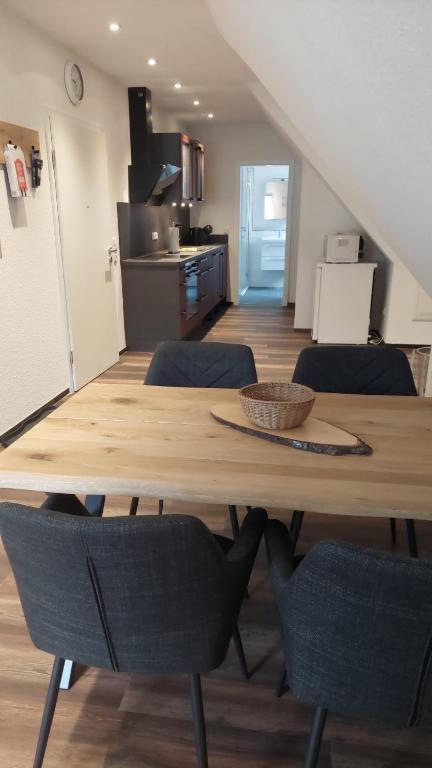 a dining room table with chairs and a kitchen at Ferienwohnung an der Holtemme in Derenburg