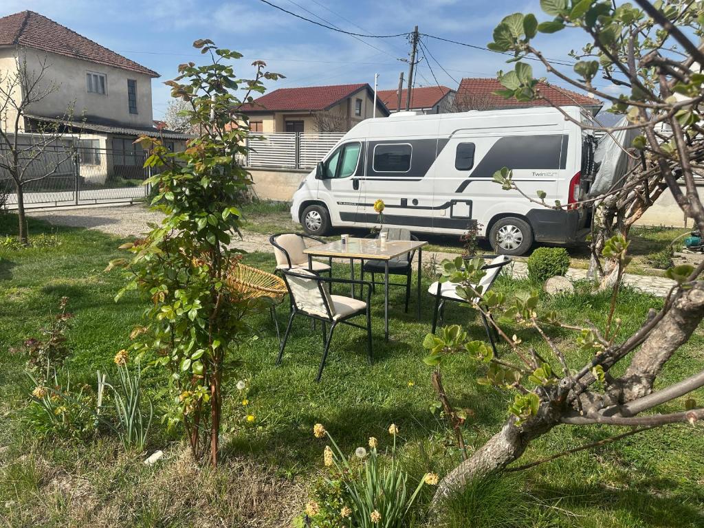 a white van parked in a yard with a table and chairs at Camping Struga Macedonia in Struga